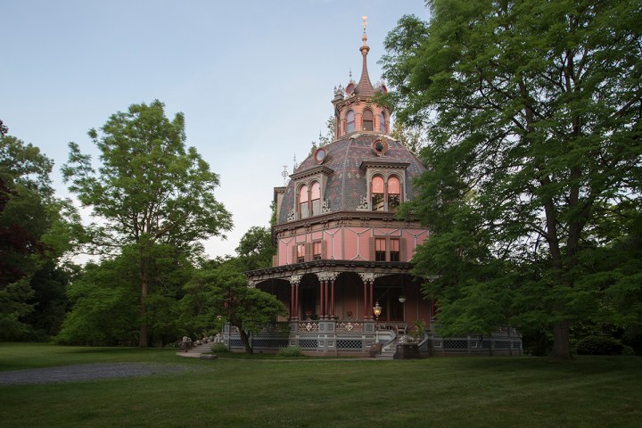 A large green lawn stretches out in front of a pink, octagonal house with a gray dome