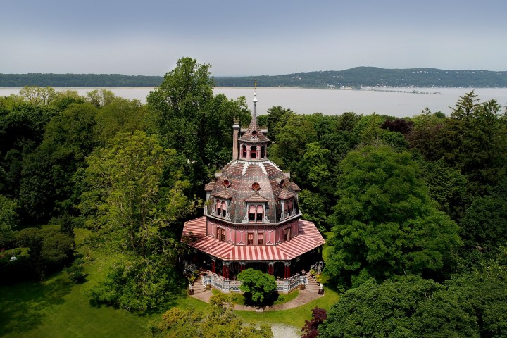 The Octagon House amid trees with the Hudson River behind