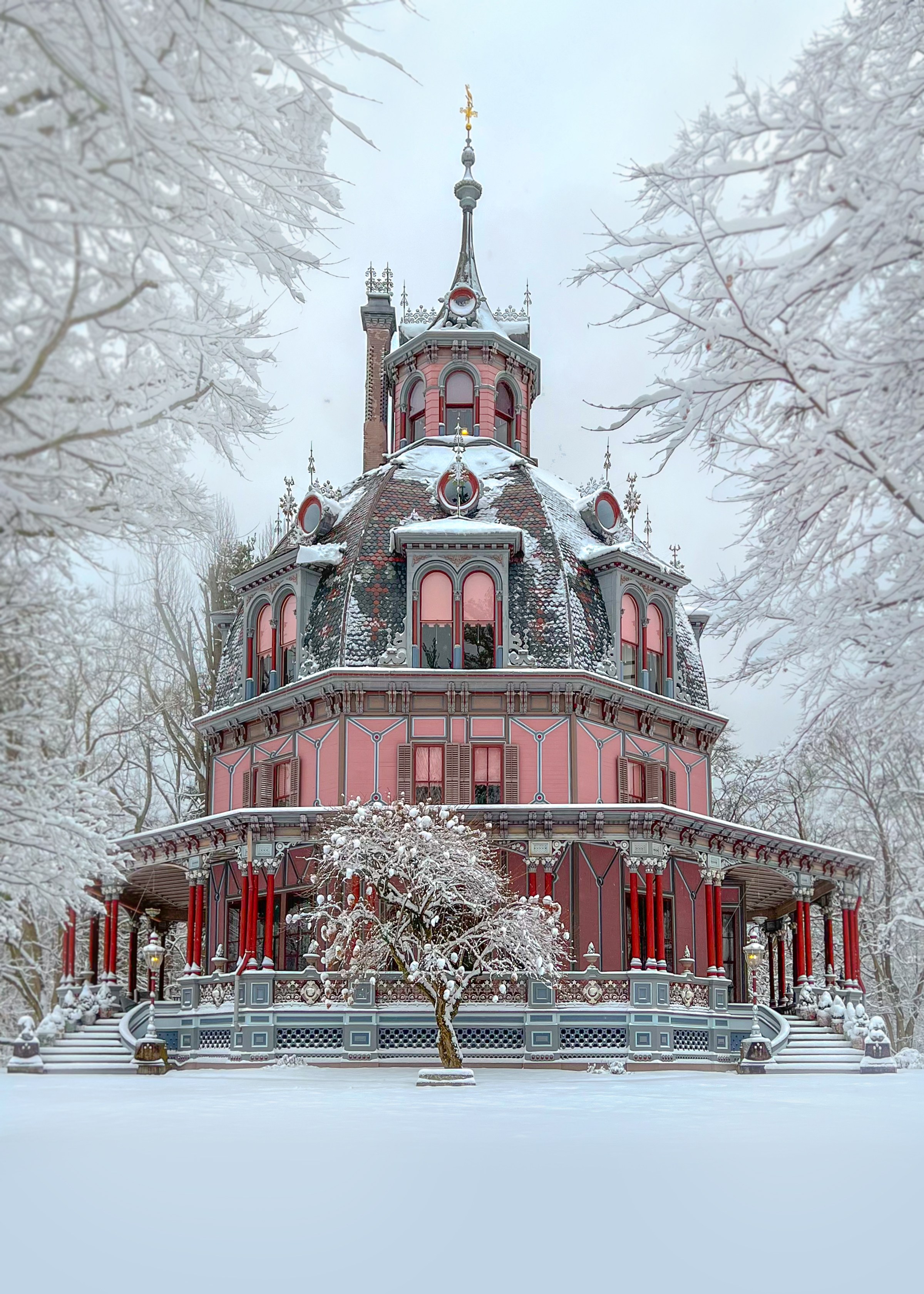 A pink octagonal house with a dome roof in a snowy landscape, surrounded by frosty trees.