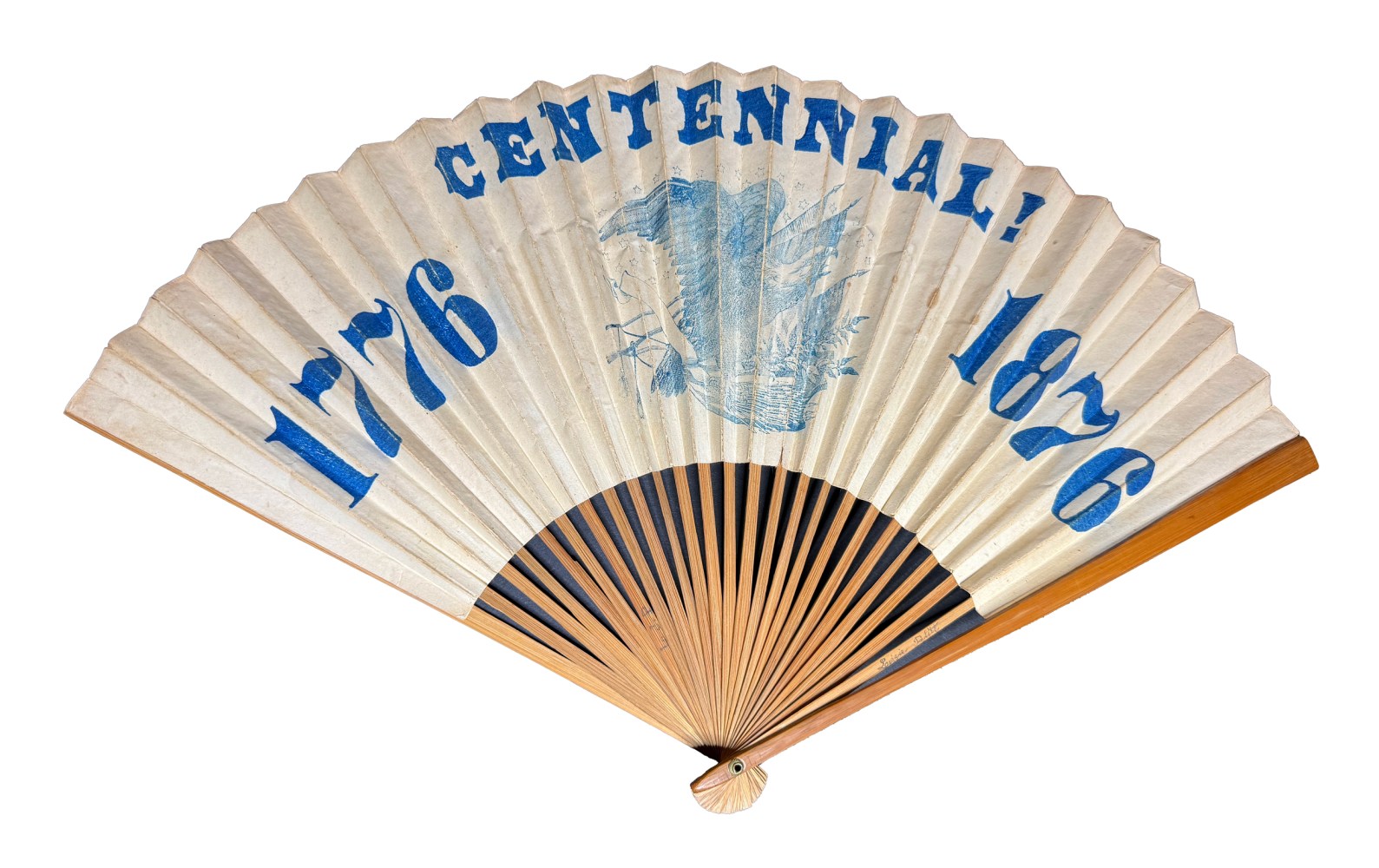 A folding fan with '1776 Centennial 1876' and eagle illustration in blue on white paper.