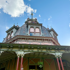 Ornate Victorian-style building with a pointed roof against a blue sky.
